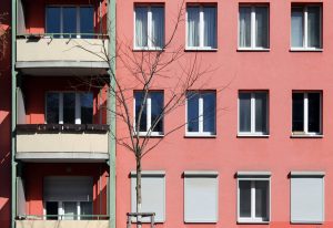 Rötliche Fassade mit Balkonen und Fenstern. Foto: Anna Jauch