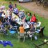 Bewohner sitzen um großen Tisch auf einer Wiese. Foto: Rico Neuber