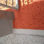 Rote und graue Wandfläche, Metallblech und Geländer