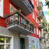 Altbaufassade rot gestrichen, Erdgeschosszone grau, Balkone auch grau