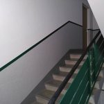 Treppenaufgang, Wand weiß und grau mit dunkelgrünem Streifen.