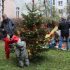 Geschmückter Weihnachtsbaum auf einer Wiese, zwei Kinder im Vordergrund, weitere Personen im Hintergrund
