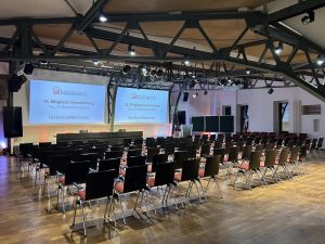 Veranstaltungsraum mit Bestuhlung und Leinwänden ohne Menschen